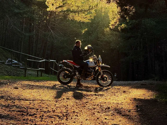 La moto en una pista de bosque al contraluz del atardecer