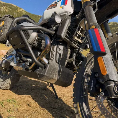 Detalle de la horquilla y el motor de la moto en una pista