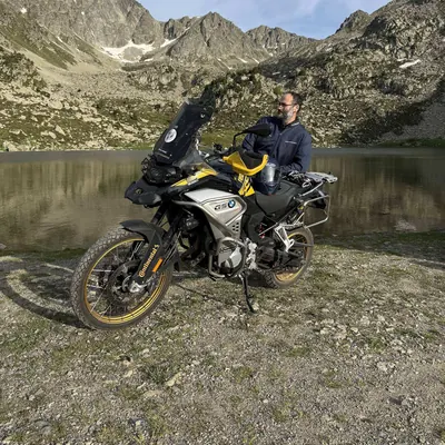 Luis con su moto junto a un lago de alta montaña