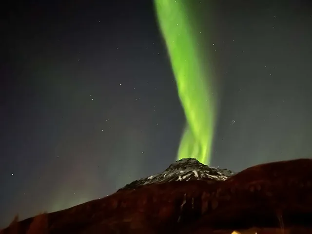 Aurora boreal verde sobre la montaña en Seyðisfjörður
