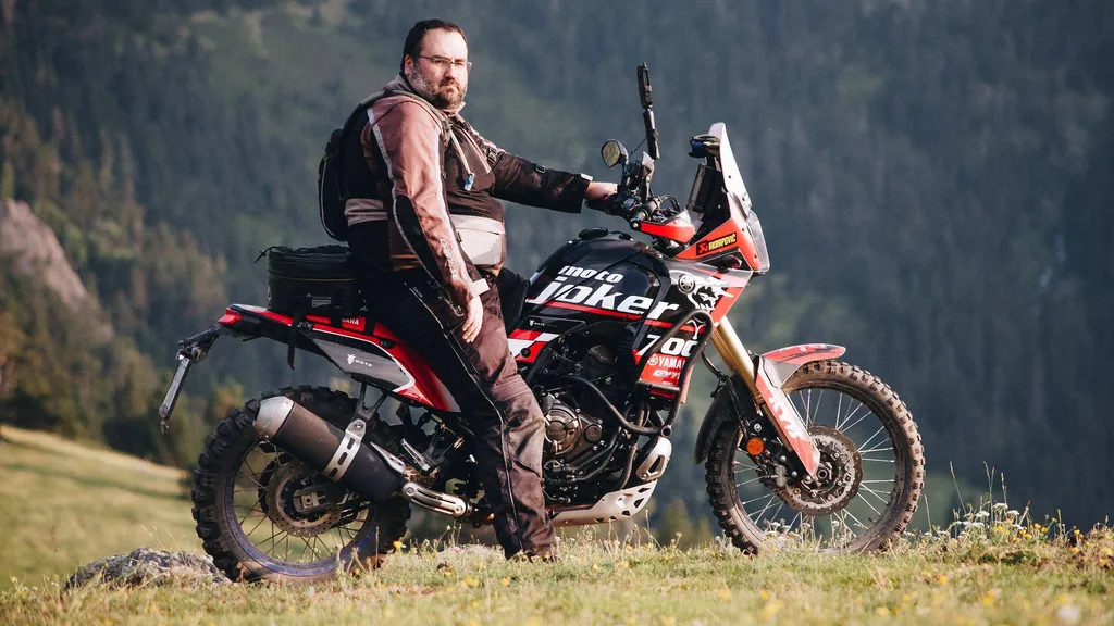Luis sentado en una Yamaha Ténéré 700 en un prado del Pirineo