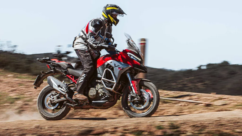 Luis rueda por una pista de tierra con una trail roja, levantando polvo, en la sesión de los Continental TKC 80