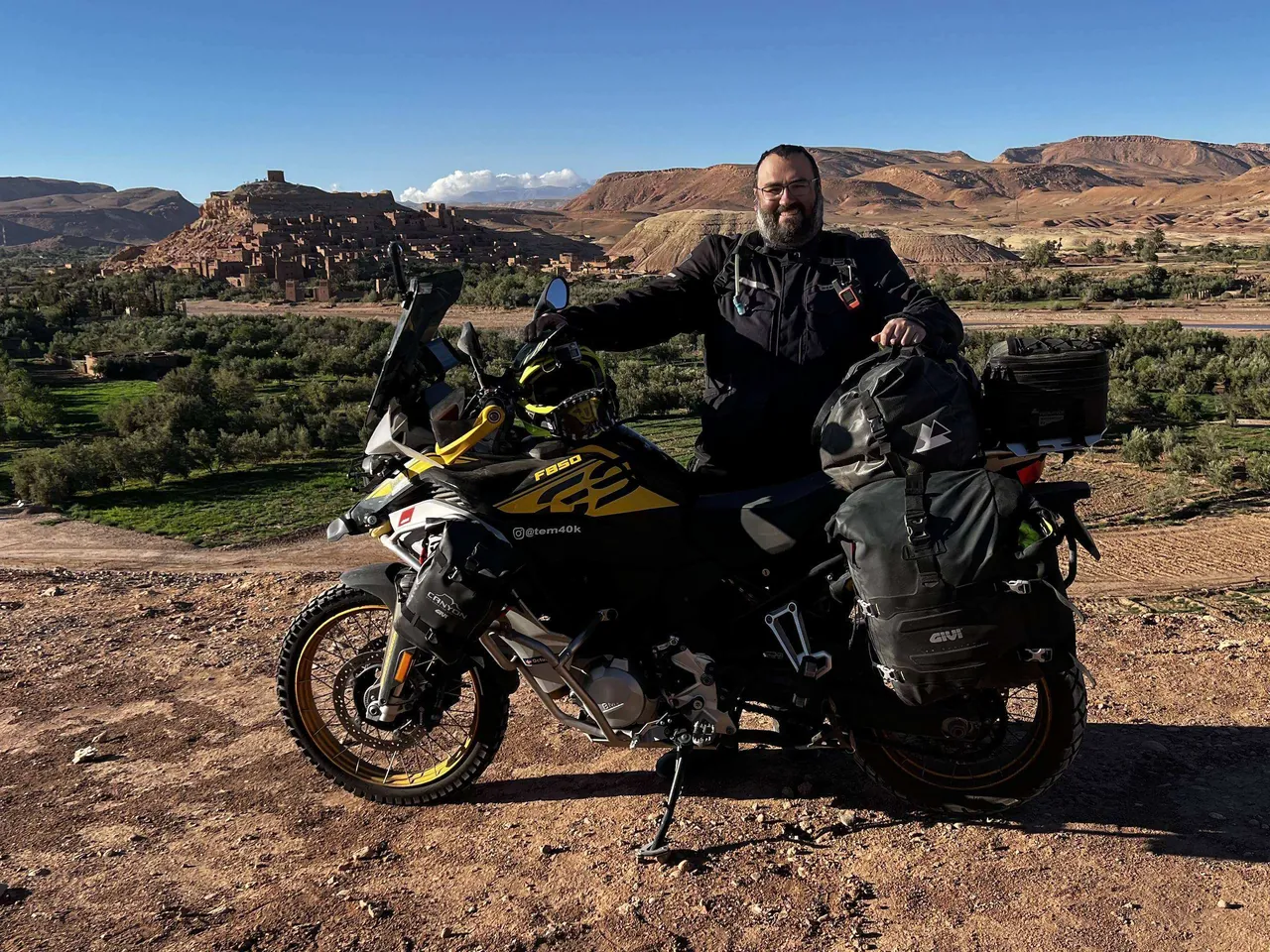 Luis junto a su moto cargada frente a la kasba de Aït Benhaddou, en Marruecos